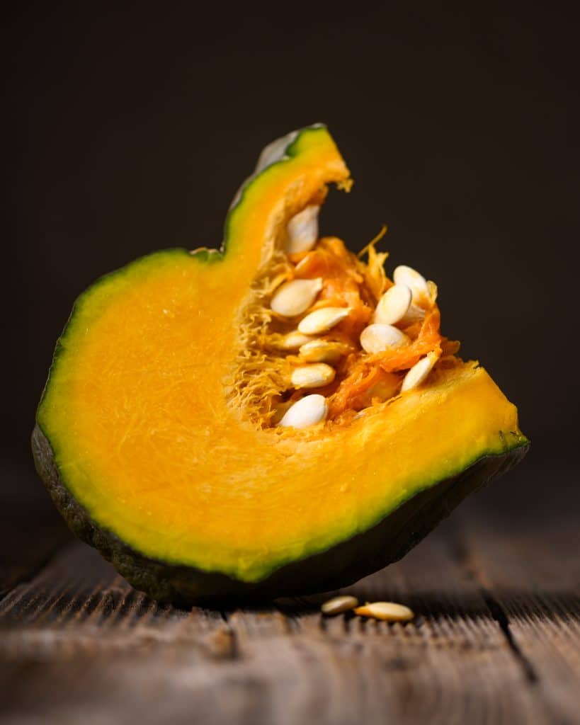 A sliced acorn squash showing its orange flesh