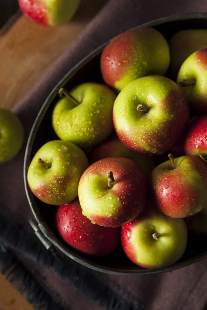 Whole fresh apples ready to eat on a wooden table