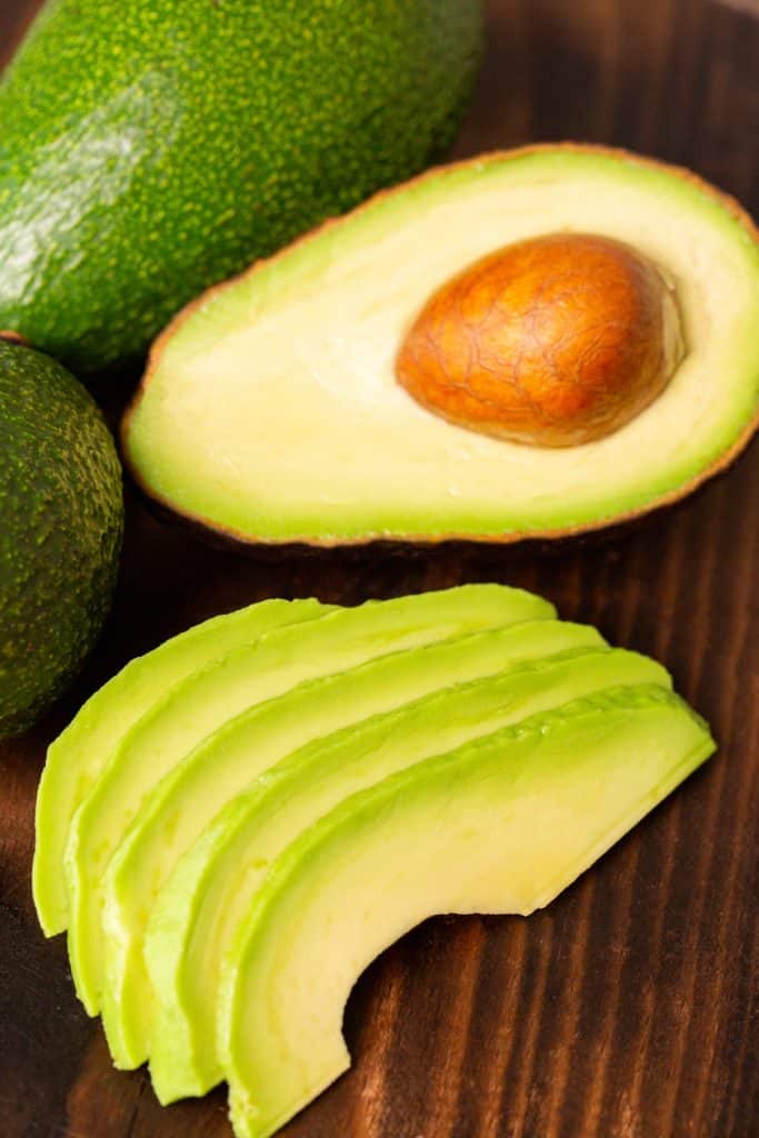 Ripe avocado slices fanned on wood