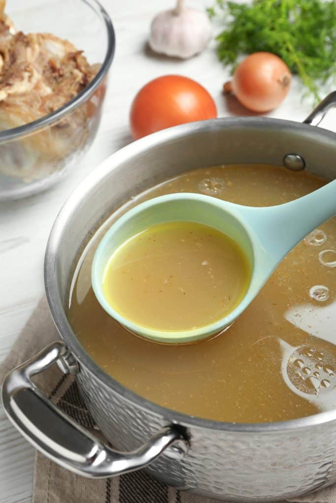 Bone broth simmering in a stainless steel pot
