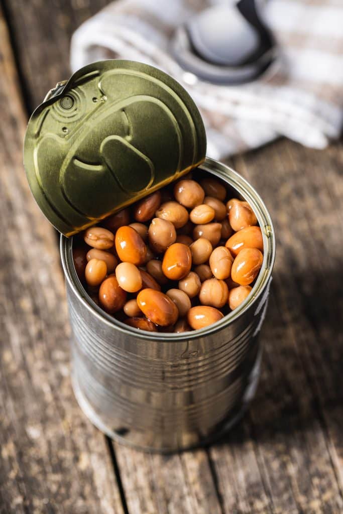 Open can of beans on a wood table