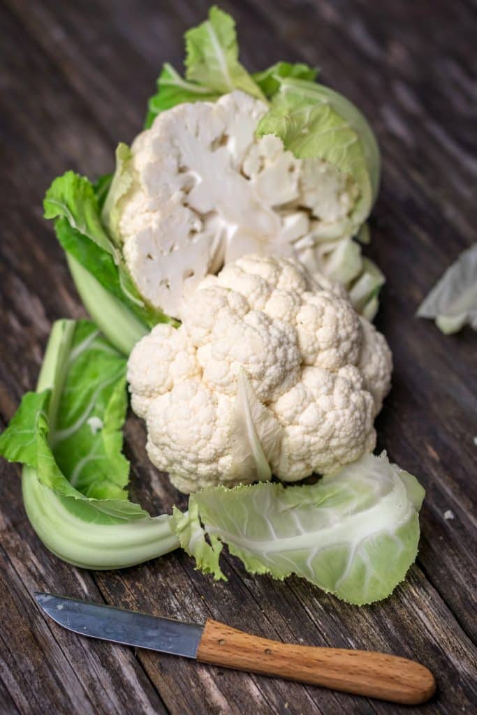 A fresh cauliflower head with leaves still attached