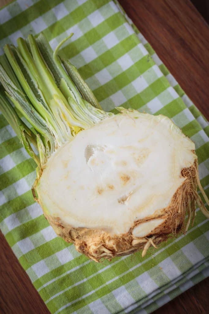 A halved celeriac root shown on a cloth