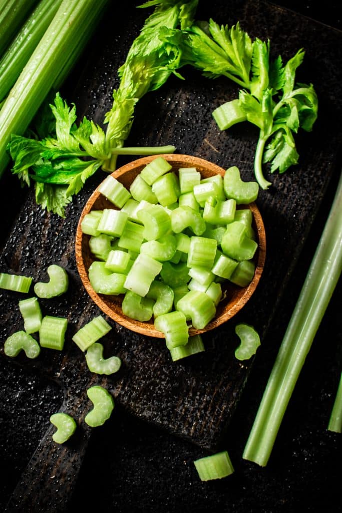 Chopped celery pieces in a small wooden bowl