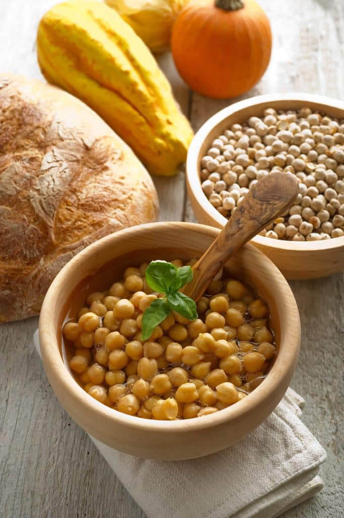 A bowl of chickpea soup with fresh basil