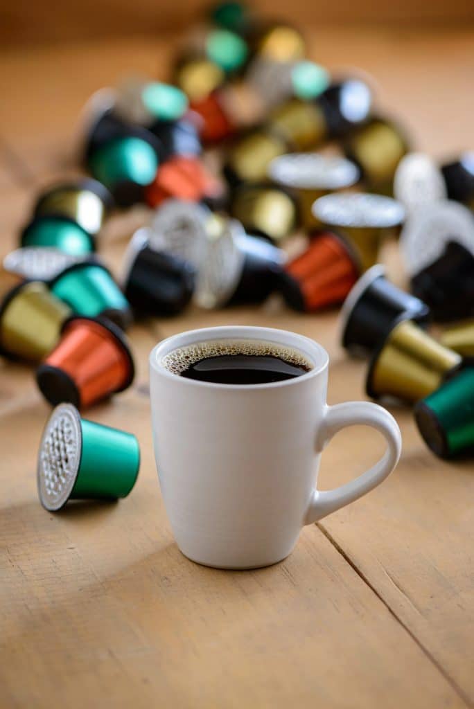 coffee pods sitting next to a mug
