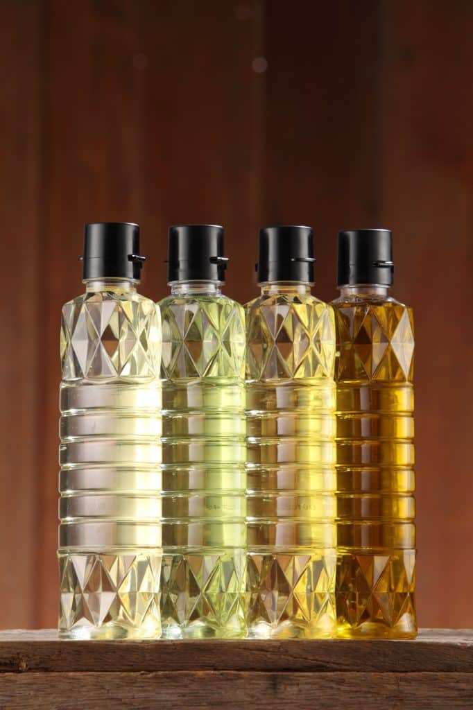 cooking oil bottles lined up on a kitchen shelf