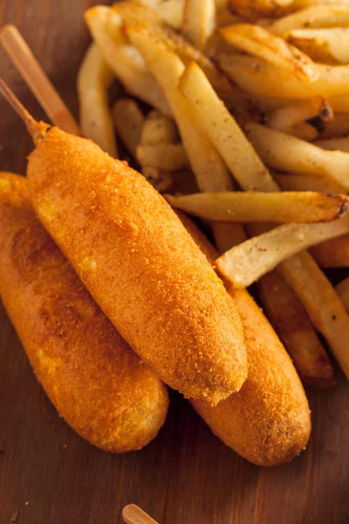 Corn dogs with mustard on a plate