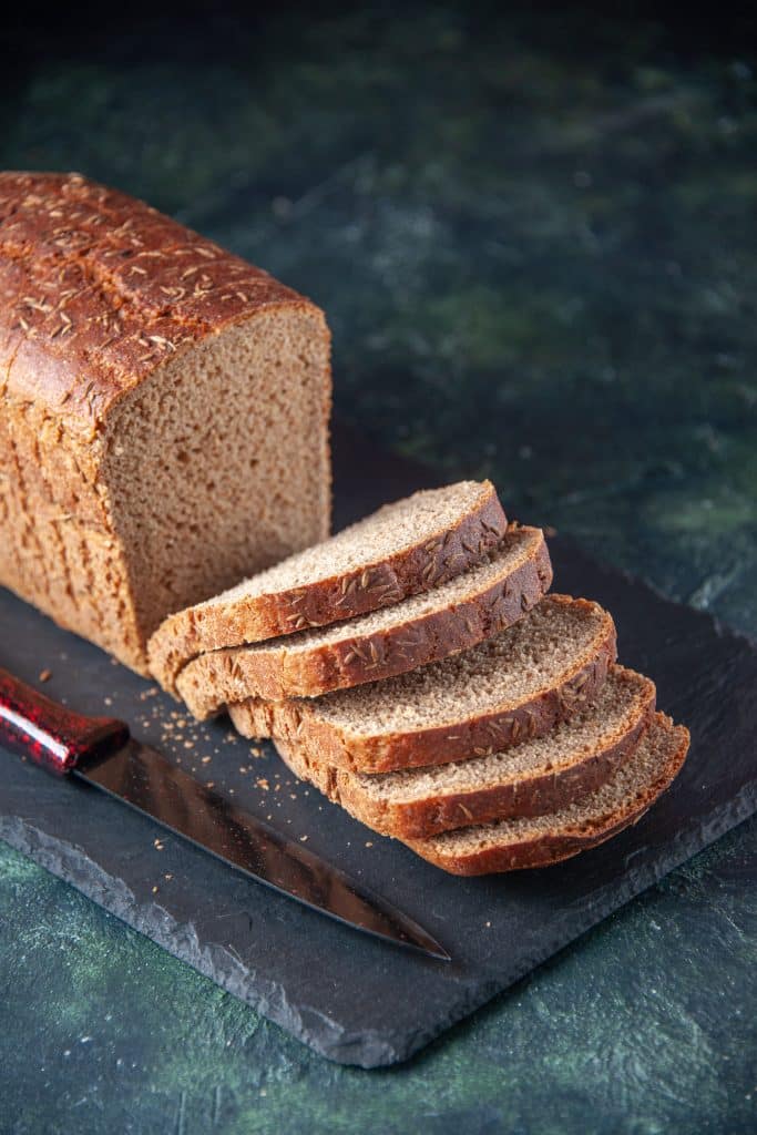 Slices of dense rye bread beside a knife