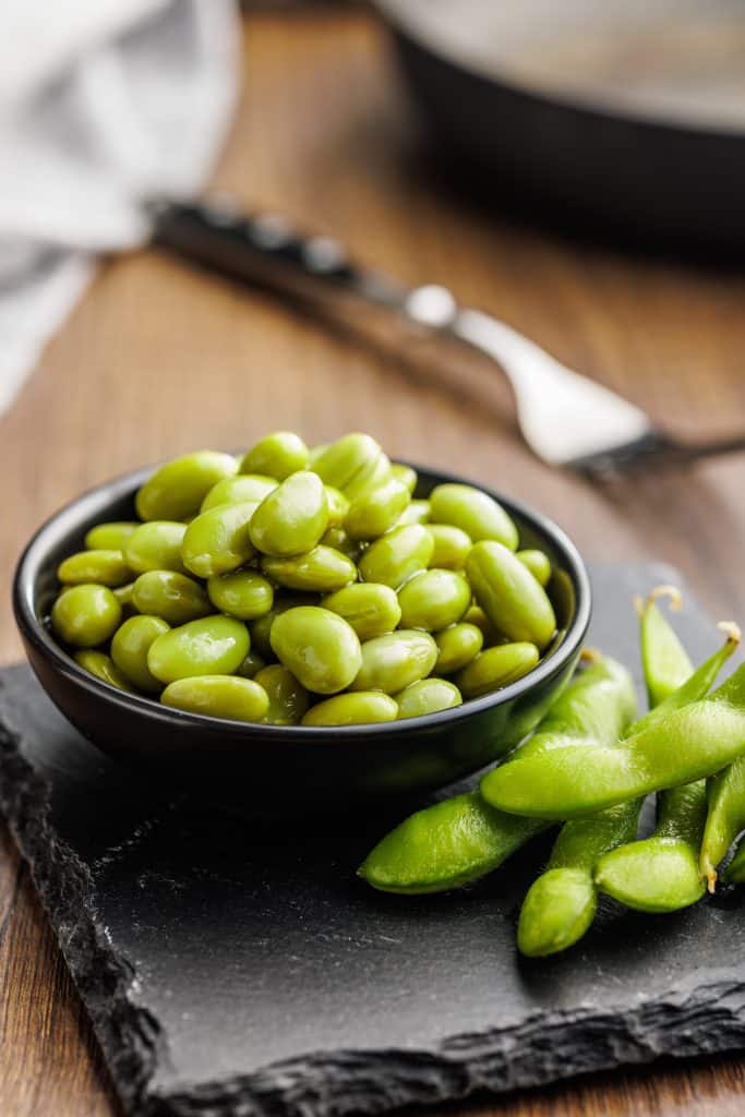 Bowl of edamame pods on a slate board