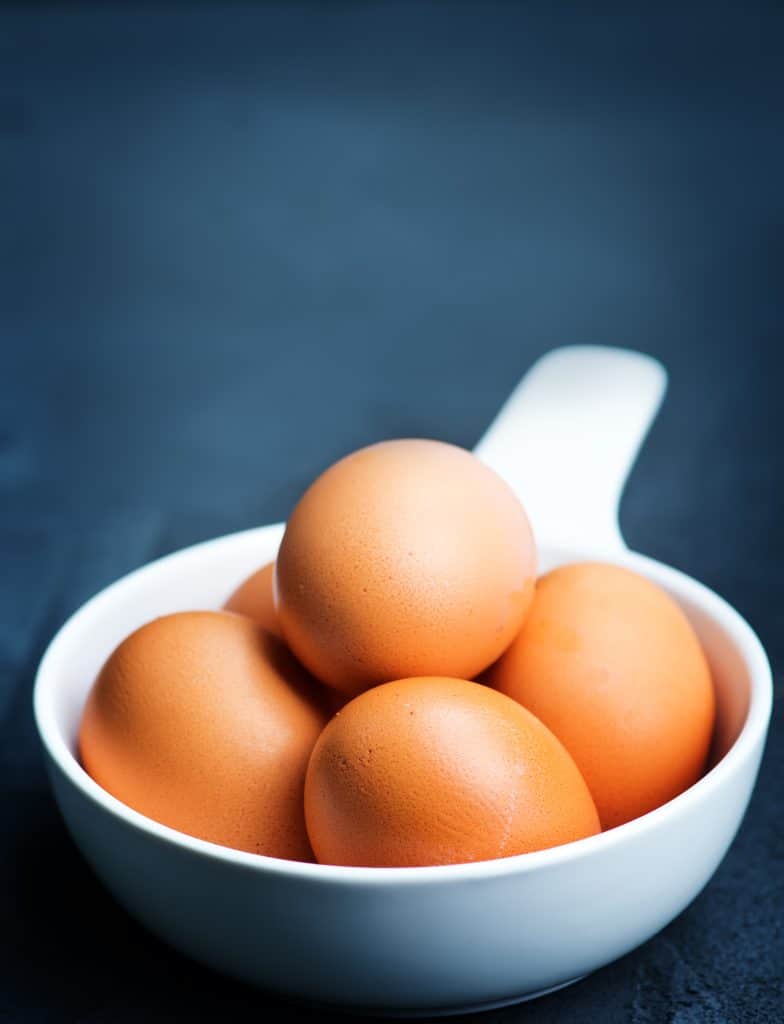 Fried eggs in a pan with herbs