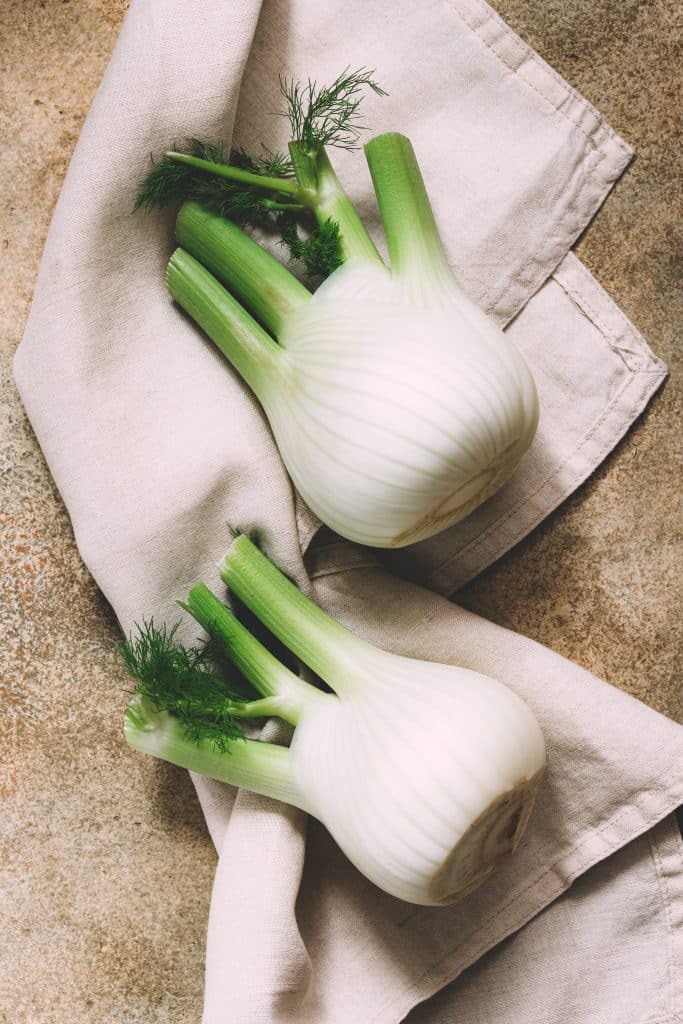 Fresh fennel bulbs on a rustic wooden surface