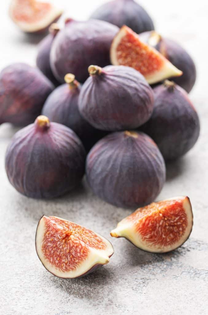 Fresh whole figs arranged on a textured surface