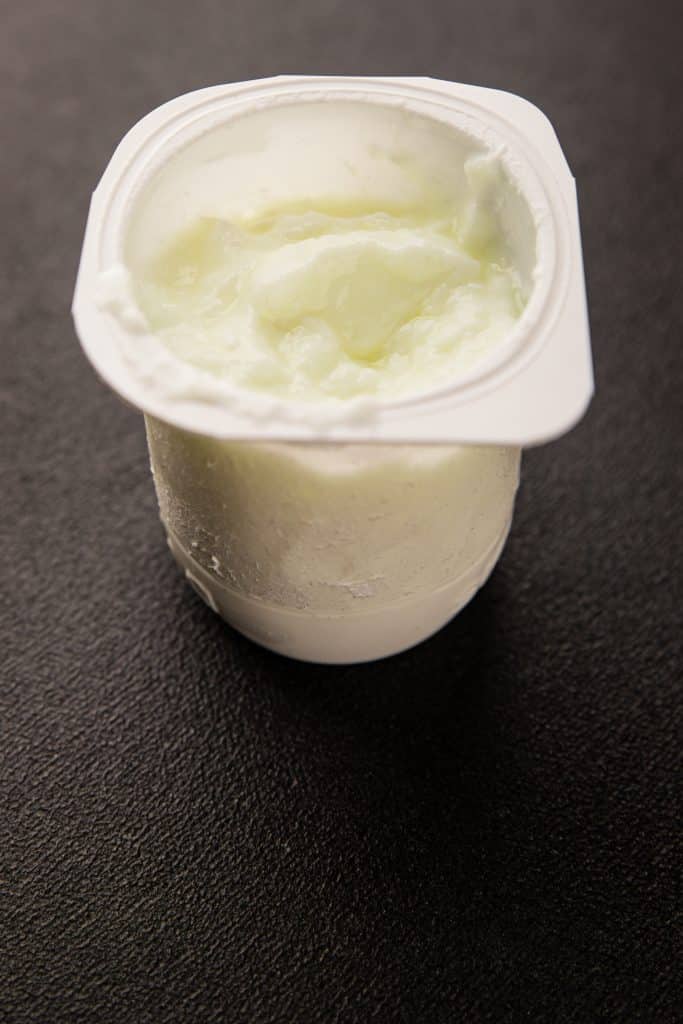 single-serve yogurt cup on a dark counter