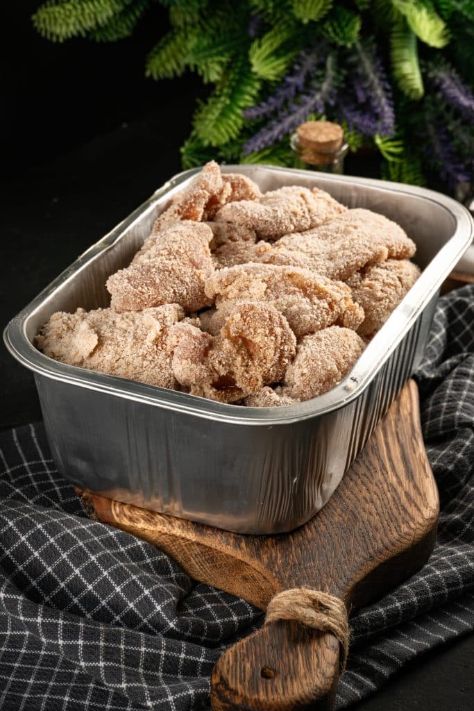 Breaded chicken tenderloins in a foil pan