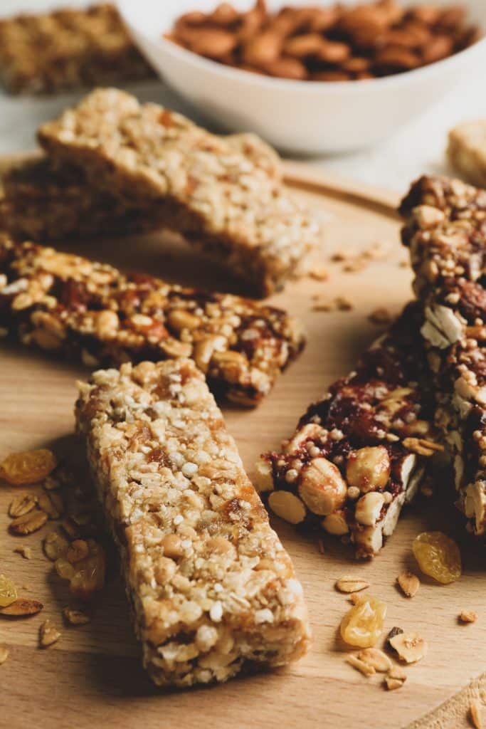 A tray of granola bars next to a bowl of almonds