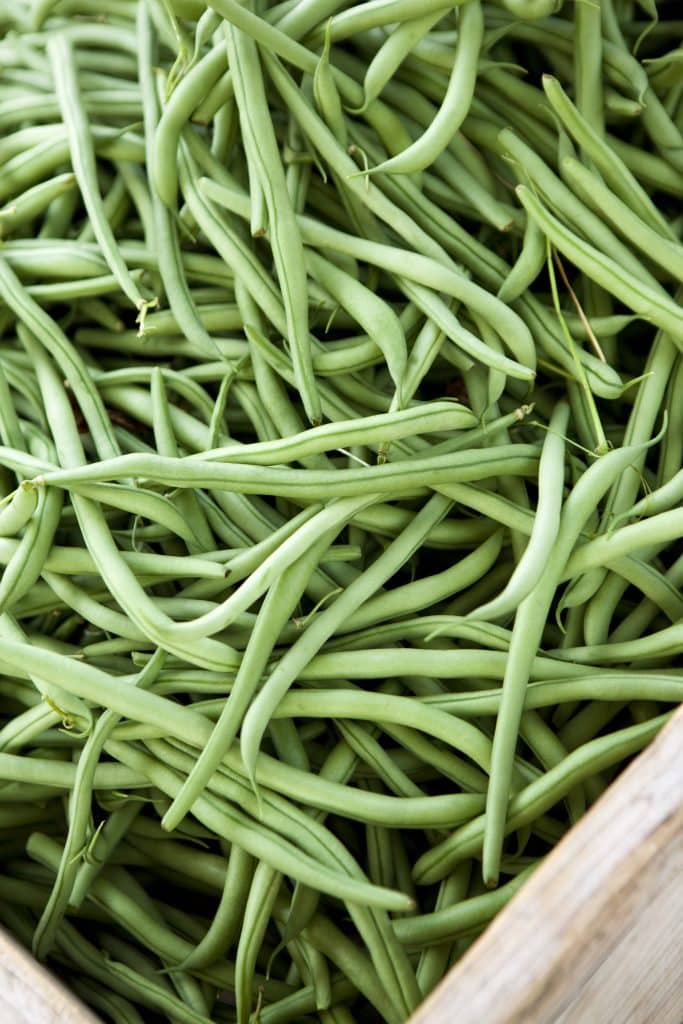 Fresh green beans piled at a market stall