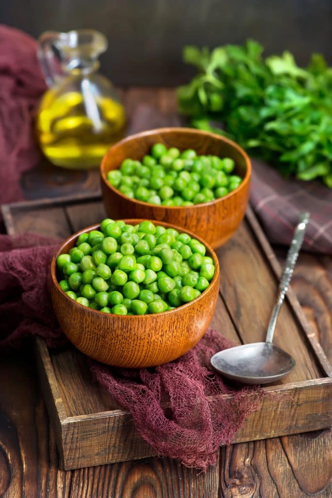 Green peas spilling out of their pods