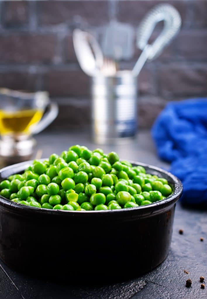 Fresh green peas spilling out of their pods