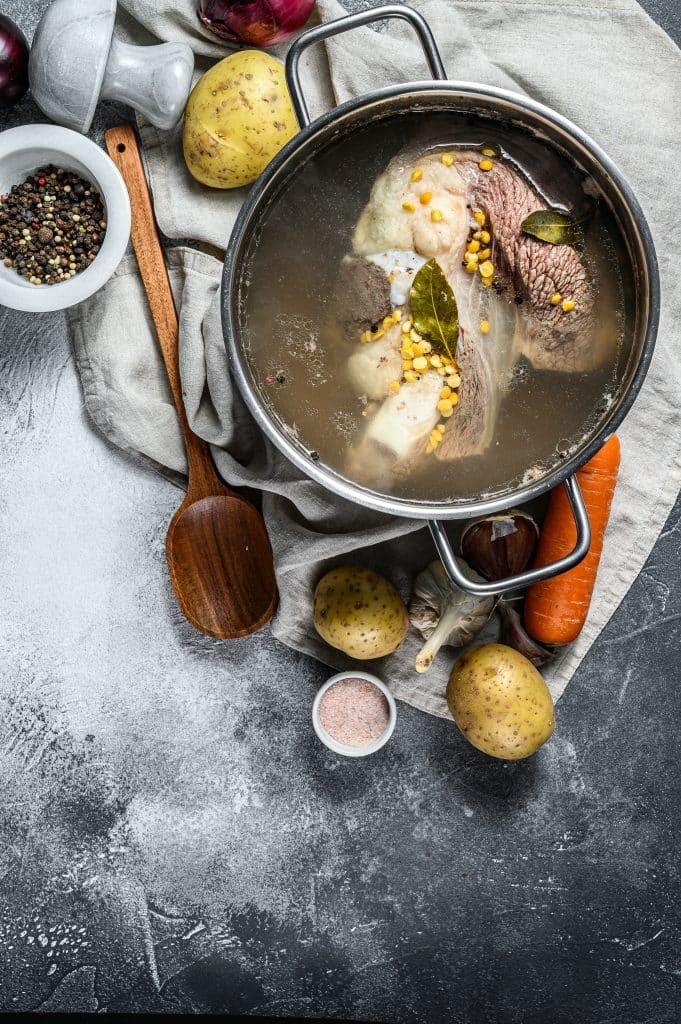 Homemade beef broth soup with vegetables and spices