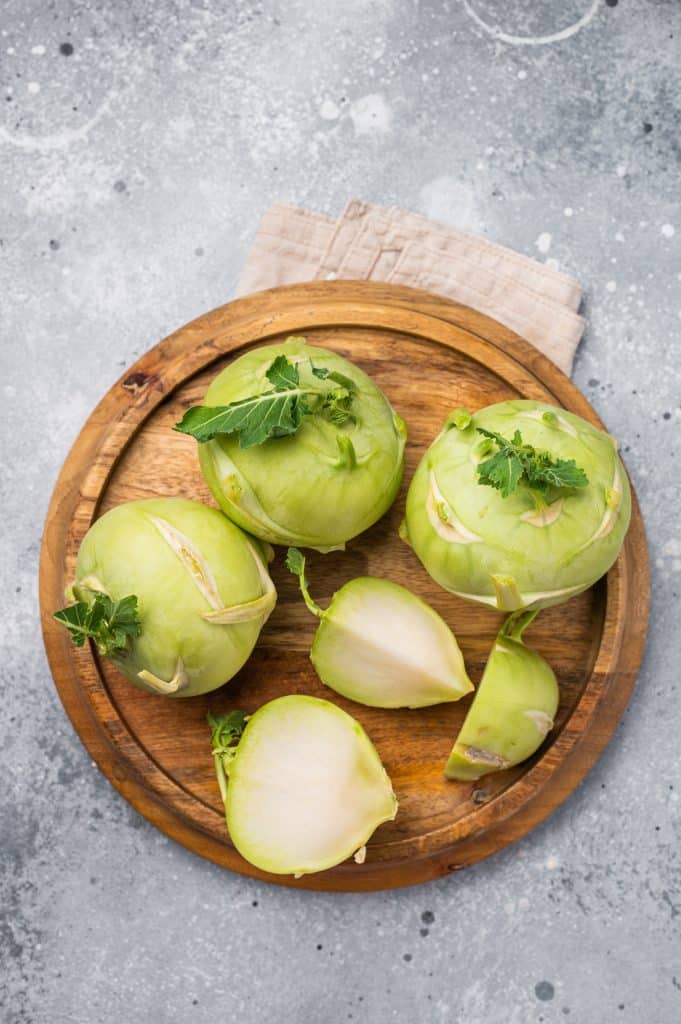 Sliced kohlrabi pieces on a wooden tray