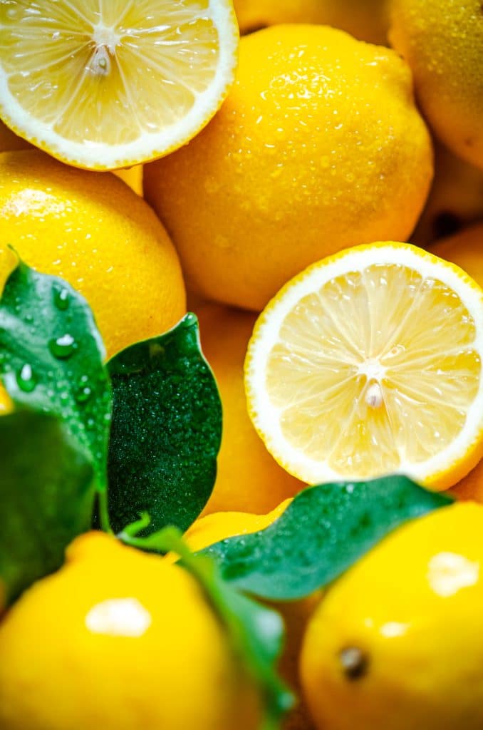 Fresh lemons with leaves and water droplets