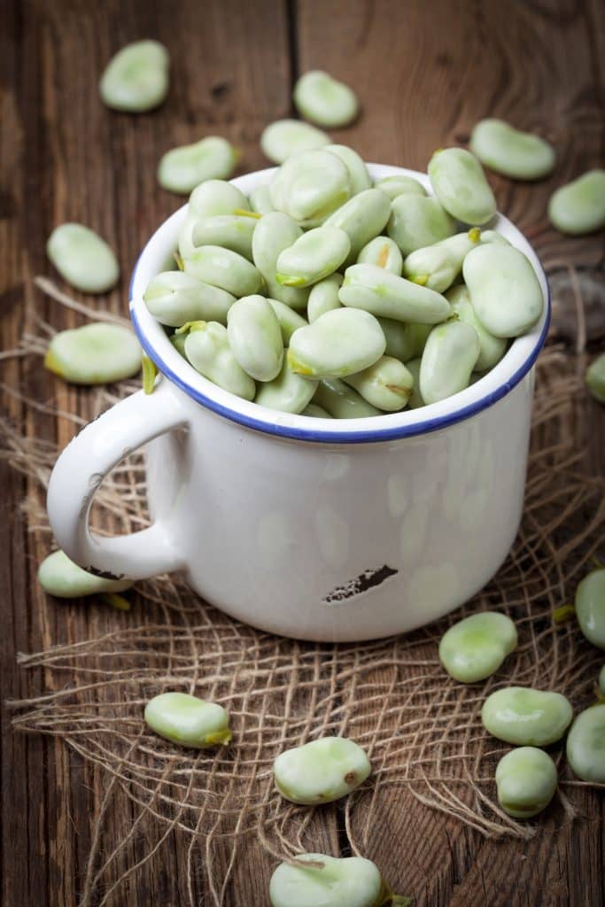 Lima beans in a rustic white cup