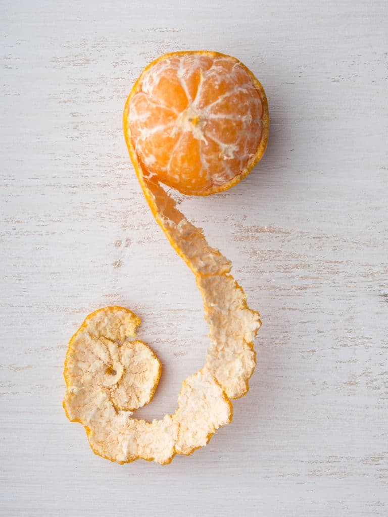 A peeled mandarin orange on a wooden background