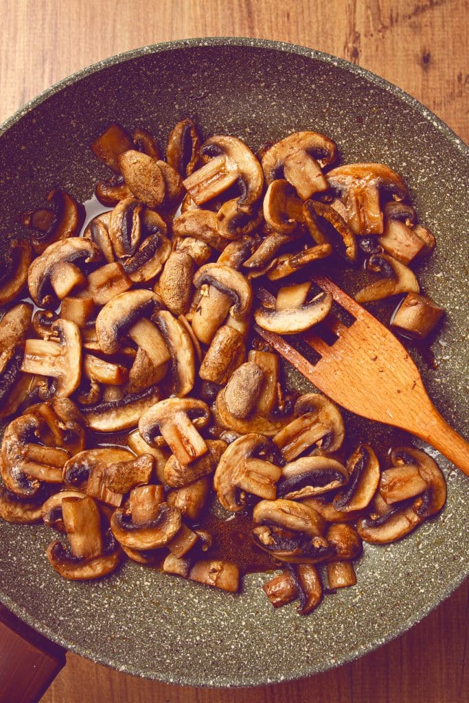 Sauteed mushrooms with butter on a wooden table