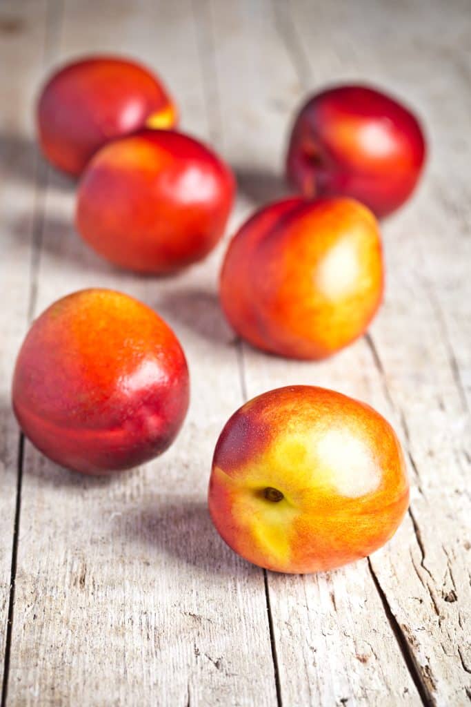 Fresh nectarines displayed on a rustic wooden table