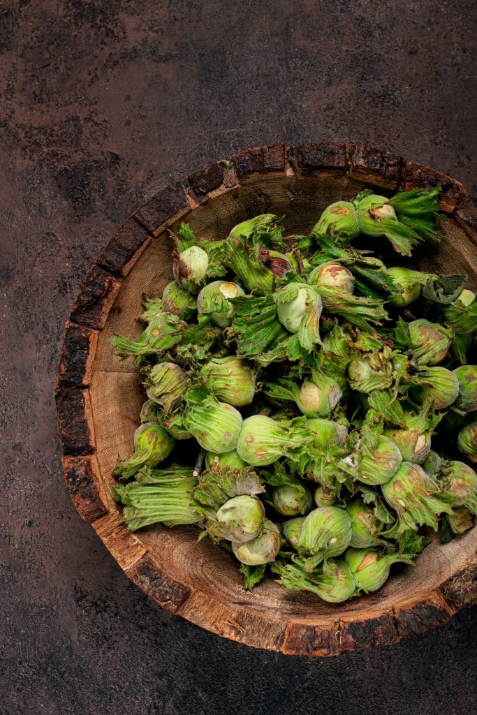 Fresh green okra pods in a wooden bowl