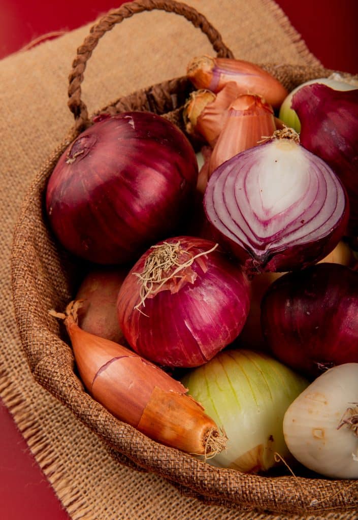Different types of onions gathered in a basket
