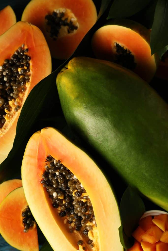 A ripe papaya with leaves shown up close