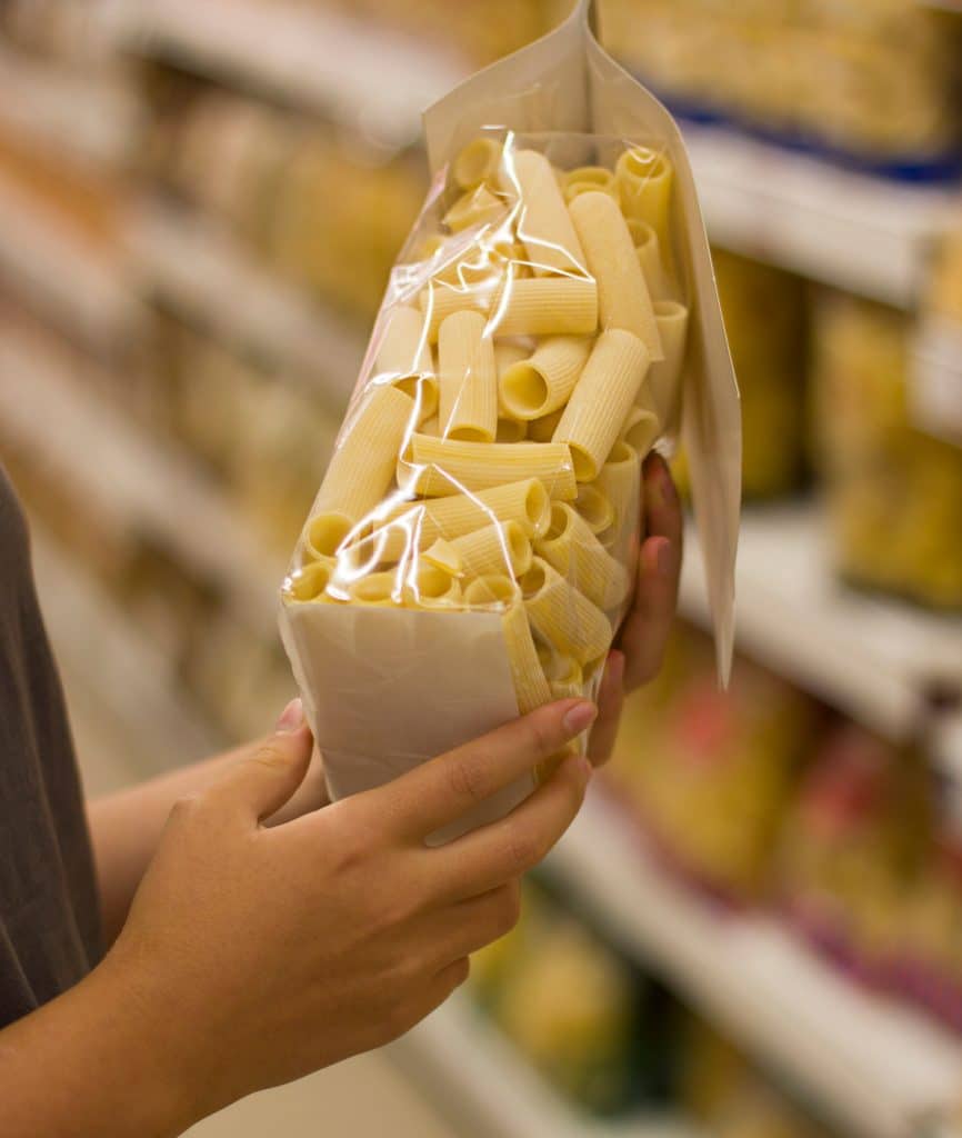 shopper choosing packaged pasta and grains at the store