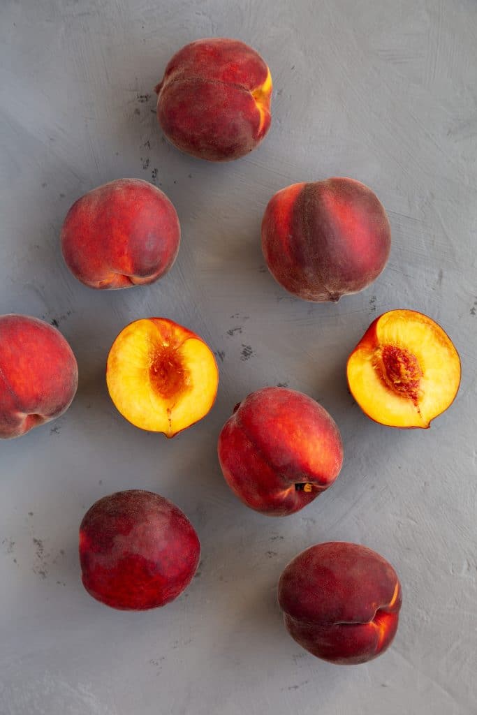 Whole yellow peaches on a gray background