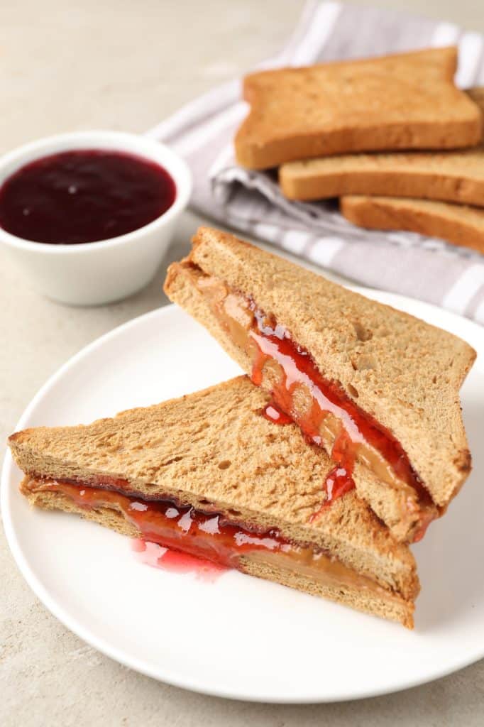 Peanut butter and jelly sandwiches stacked on a plate