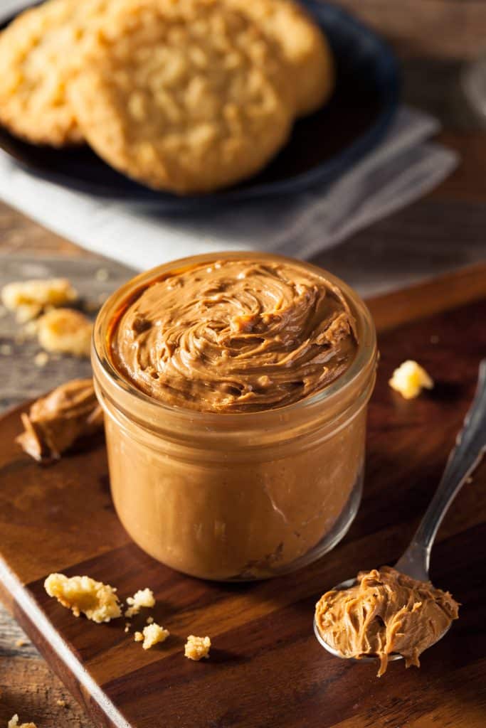 A jar of peanut butter open on the counter