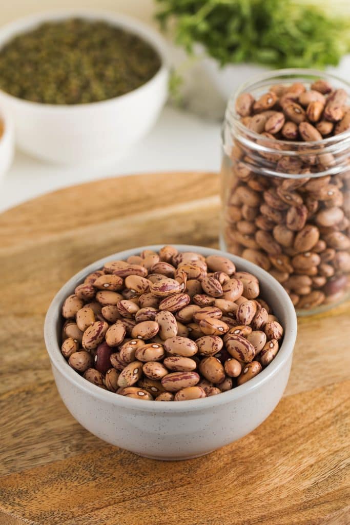 Dried pinto beans in a bowl and glass jar