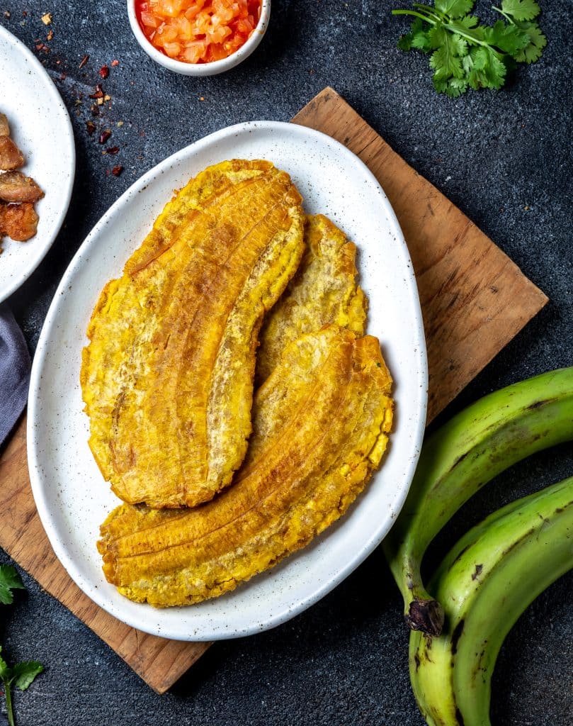 Fried plantain slices served alongside a traditional meal
