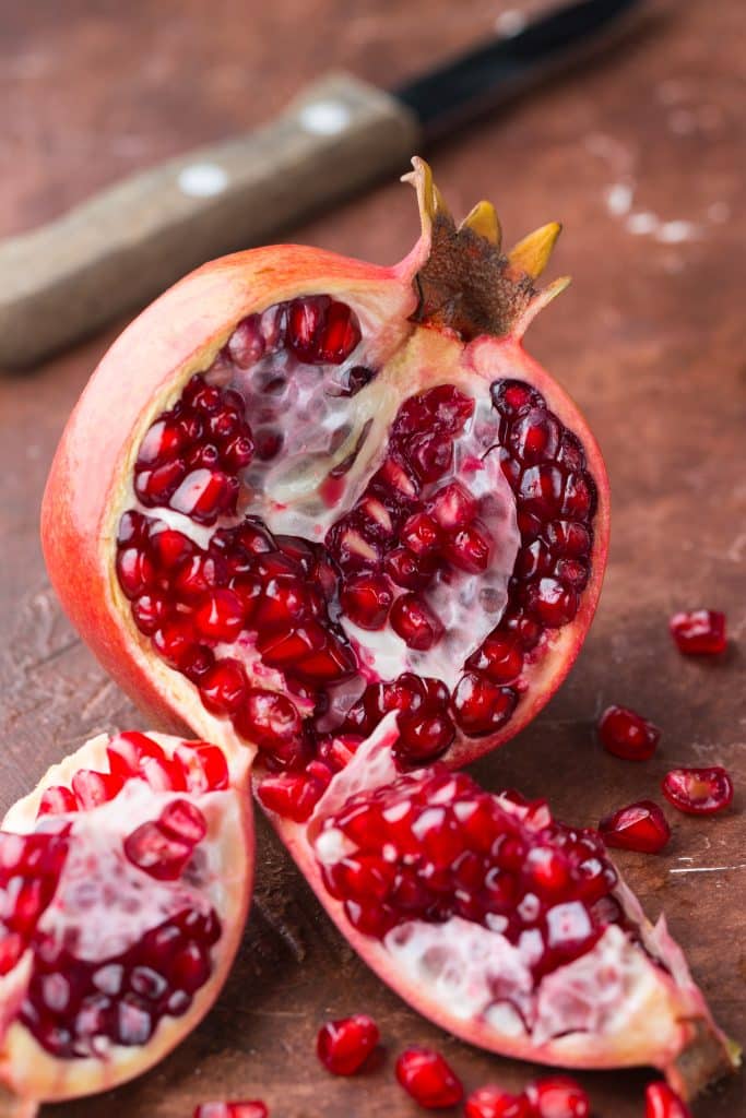 A pomegranate cut open showing its juicy seeds