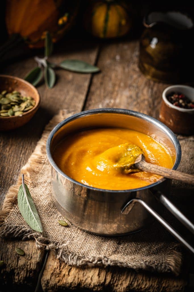 A bowl of hearty pumpkin soup on a rustic table