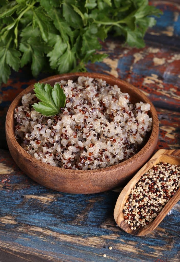 Bowl of cooked quinoa garnished with parsley