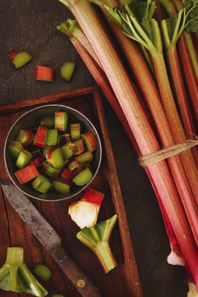 Fresh rhubarb stalks and cut pieces on a tray