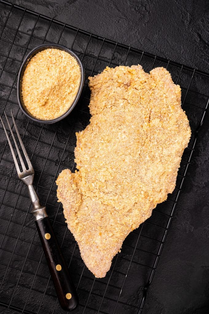 Breaded pork chops on a baking sheet