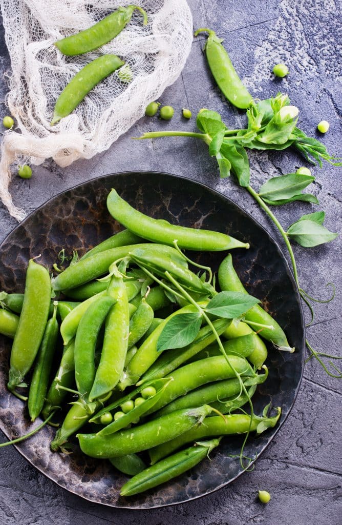 Bright green snap peas in their pods