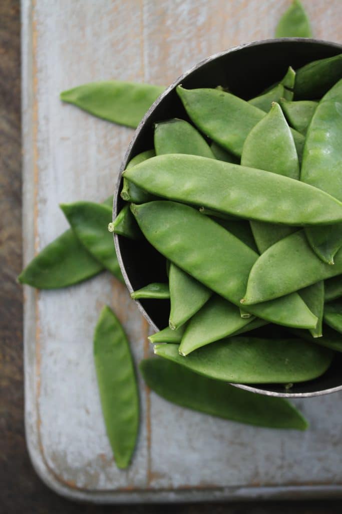 Fresh snow peas in a metal bowl