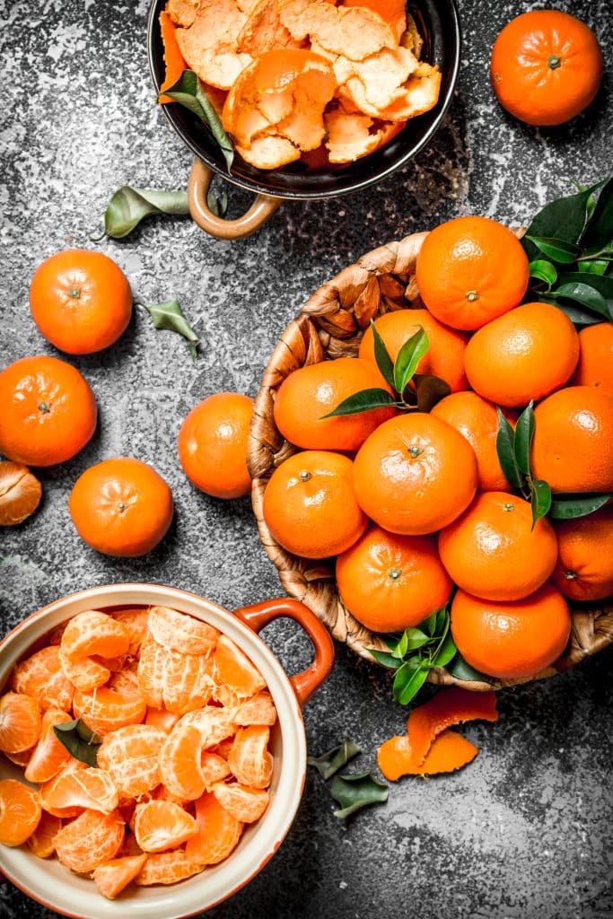 Peeled tangerines with green leaves