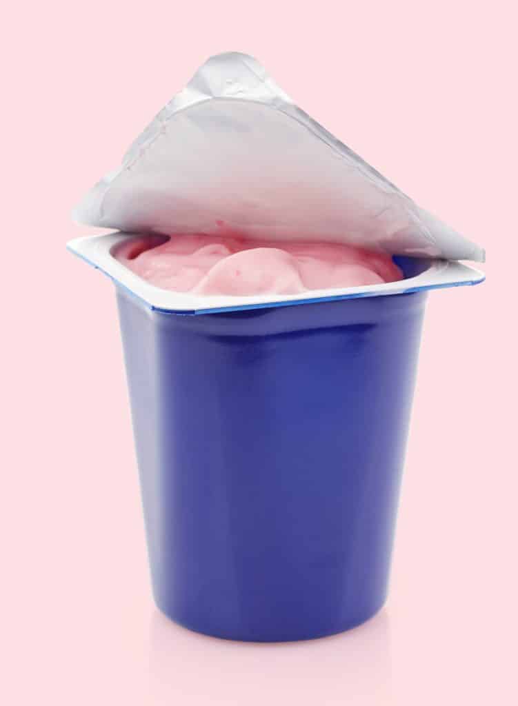 yogurt in a plastic tub sitting on the counter